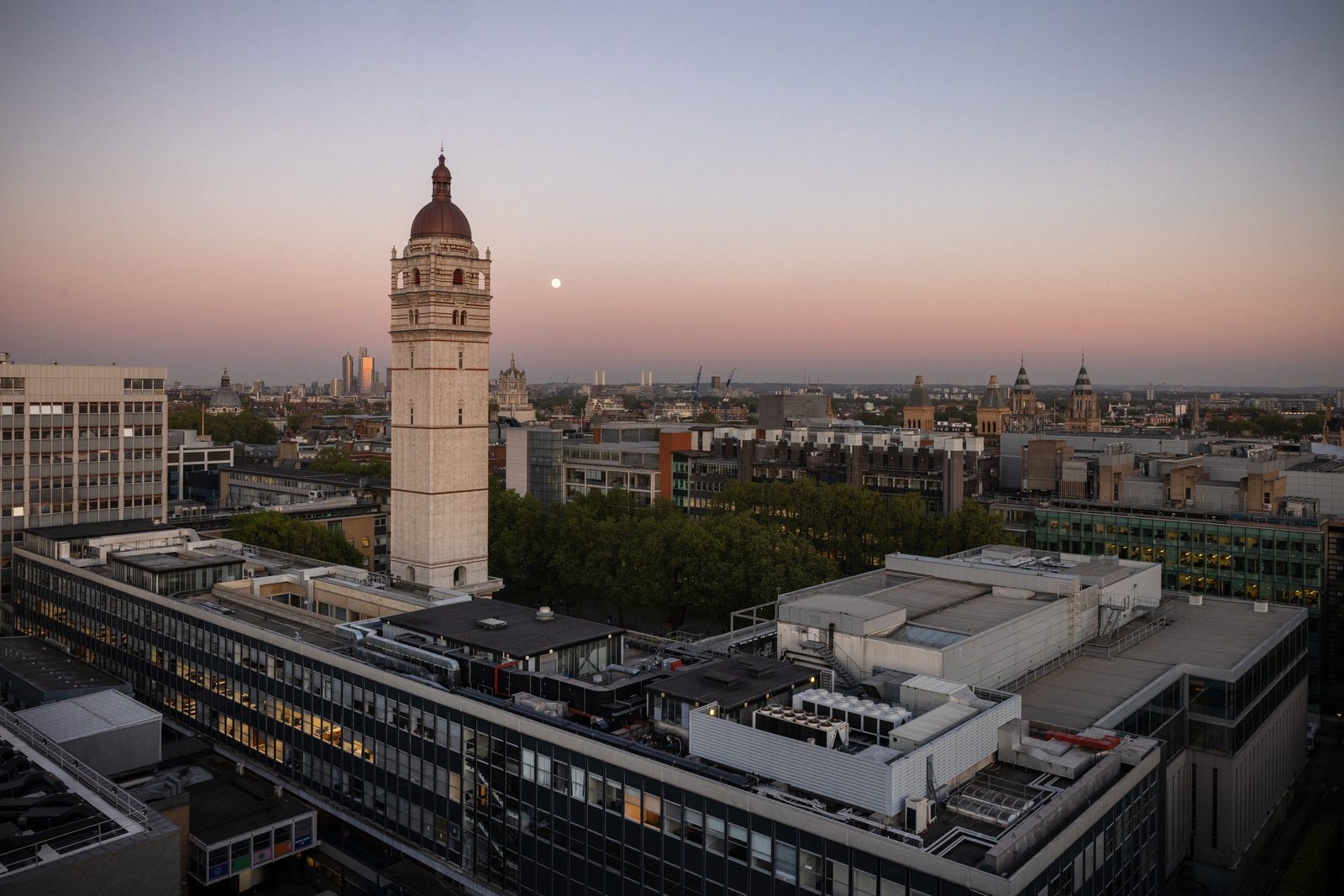 Imperial College London's South Kensington campus at dusk, Queen's Tower lit by the last of the sun with the moon risen beside it
