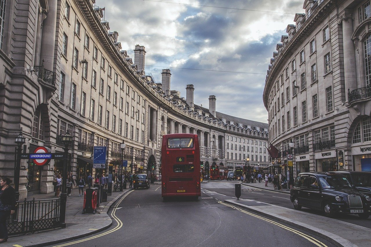 Regent Street: a red double-decker bus, black cabs and crowds on the pavement beneath the curved terraces