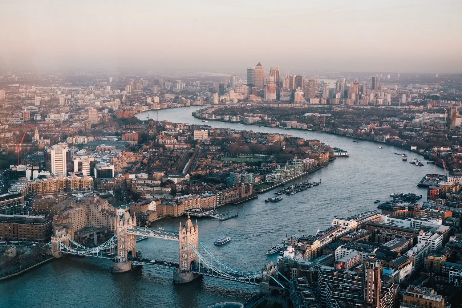 The Thames from above at dusk, Tower Bridge in the foreground and Canary Wharf beyond